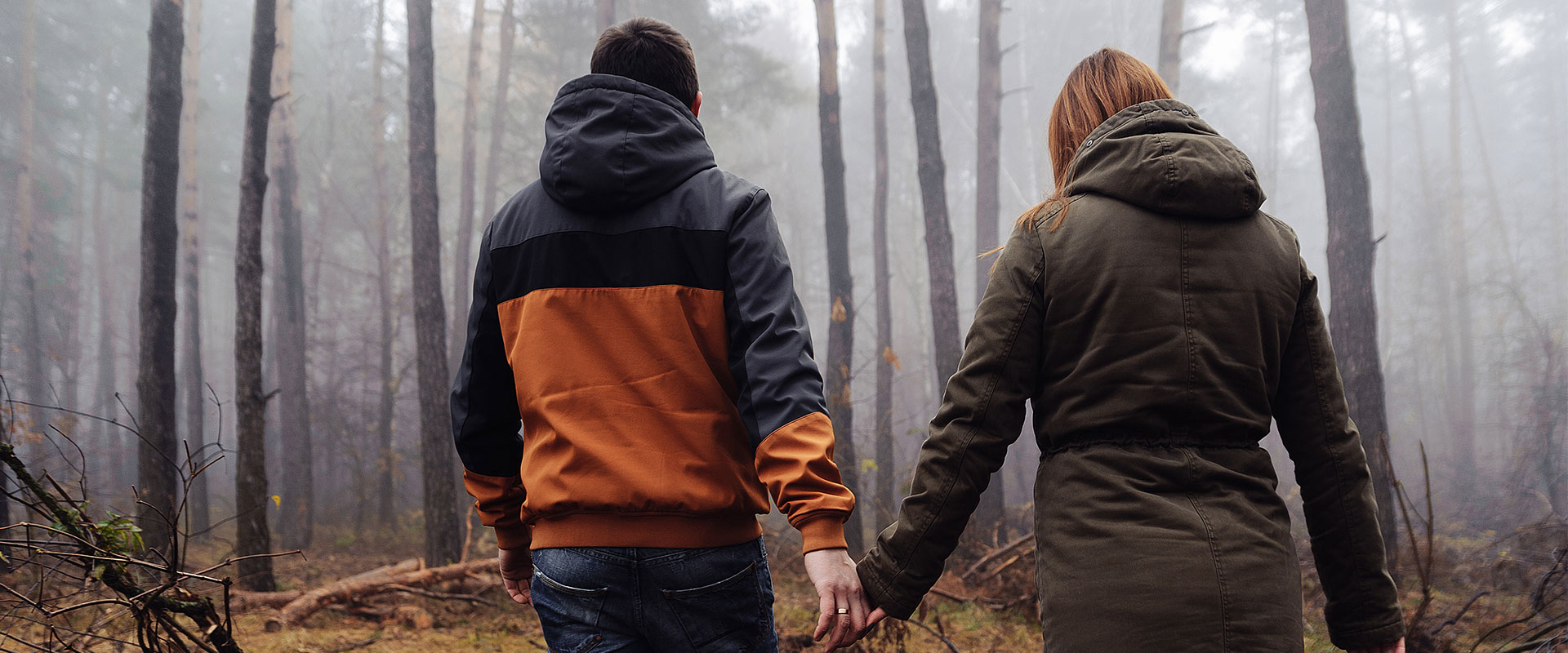 two people walking in dark woods