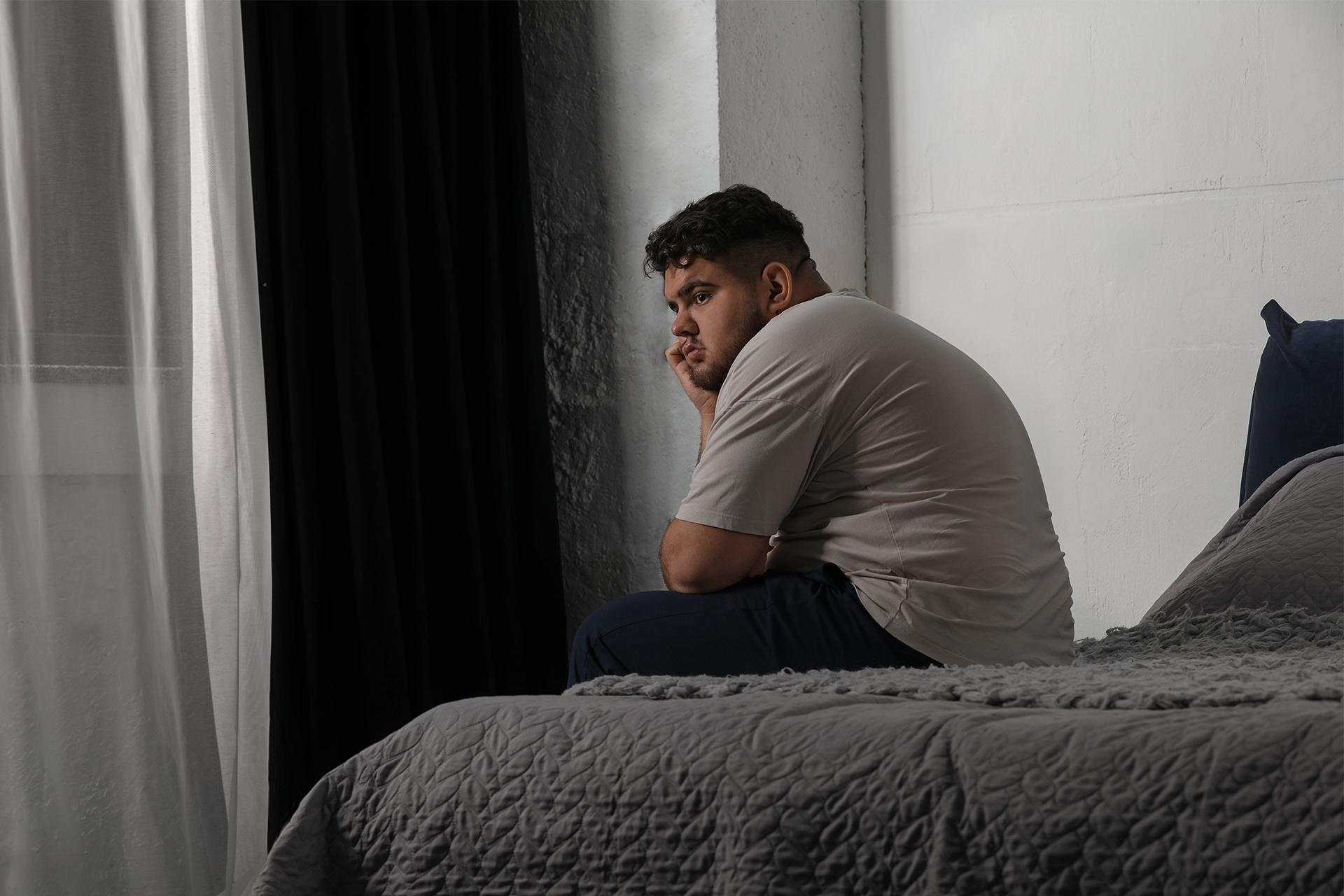 man sitting on edge of bed